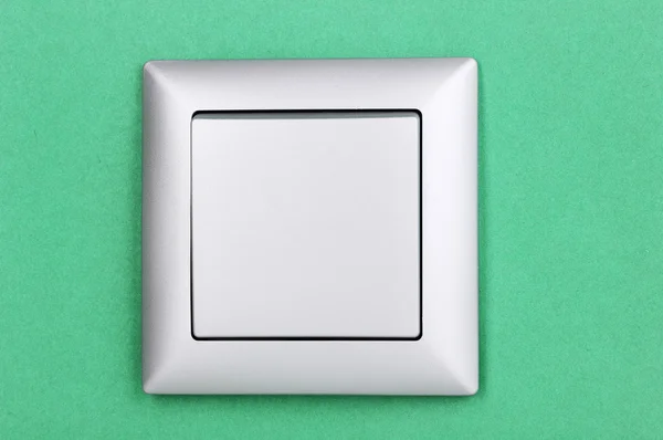 Современный выключатель света на зеленом фоне — стоковое фото
