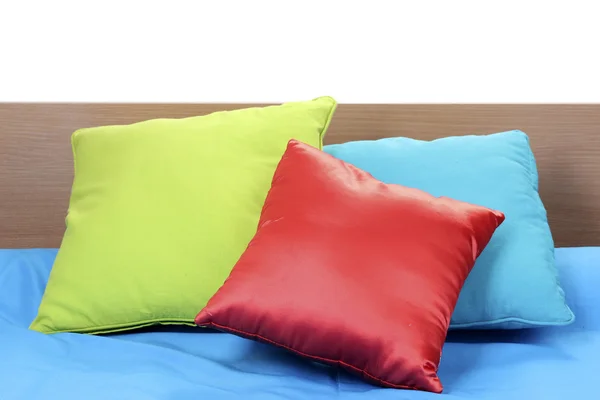Bright pillows on bed on white background — Stockfoto