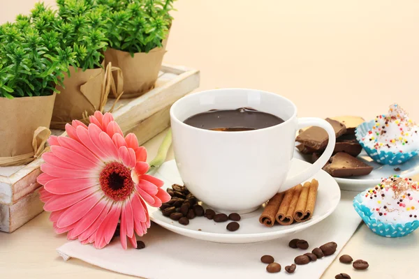 Taza de café y gerberas, palitos de canela en la mesa de madera — Foto de Stock