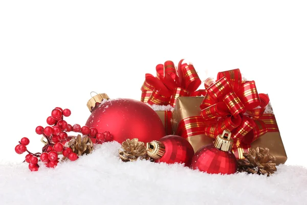 Krásné červené vánoční koule, dárků a šišky na izolovaných na bílém sněhu — Stock fotografie