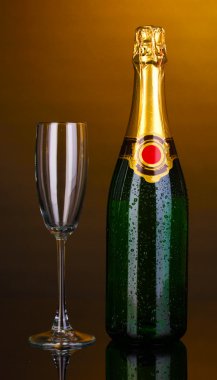 Bottle of champagne and goblet on brown background clipart