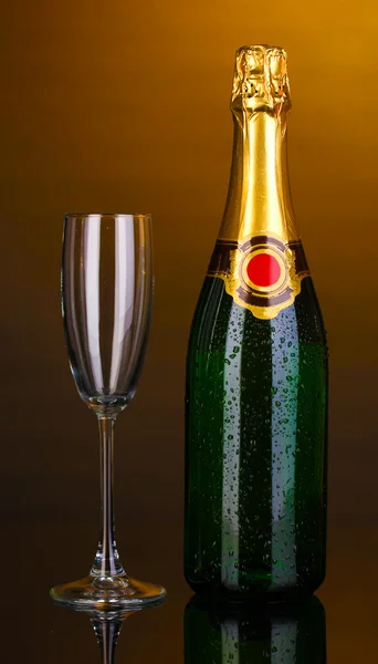 Garrafa de champanhe e cálice no fundo marrom — Fotografia de Stock