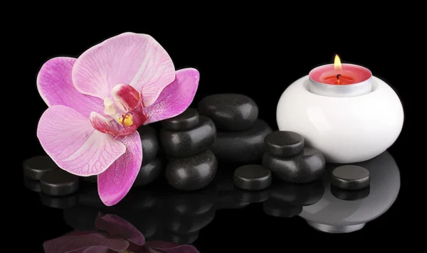 Orkide çiçek ve mum üzerine siyah izole Spa taşlarla — Stok fotoğraf