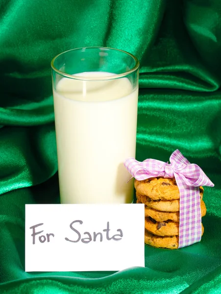 Glas Milch und Kekse auf grünem Tuch Hintergrund — Stockfoto