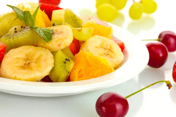 Färsk fruktsallad på plattan och bär isolerad på vit — Stockfoto