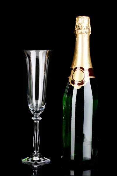 Láhev šampaňského a pohár izolovaných na černém — Stock fotografie