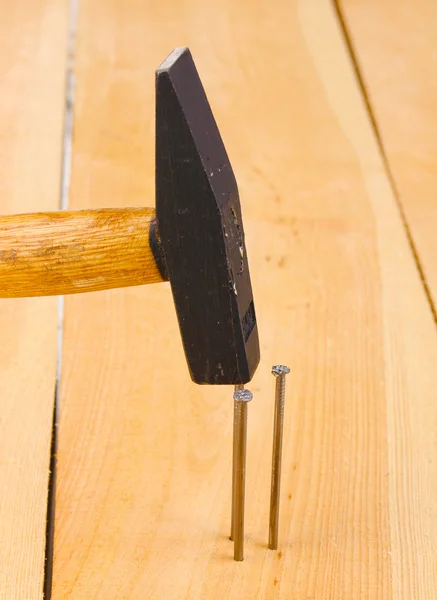 木の板とハンマーで金属の釘 — ストック写真
