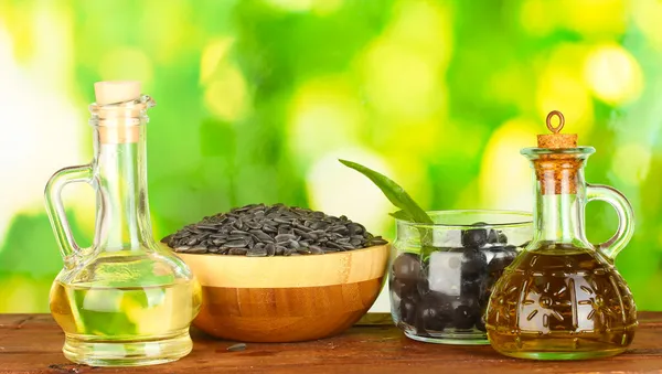 Olivový a slunečnicový olej v malé karafy na zeleném pozadí detail — Stock fotografie