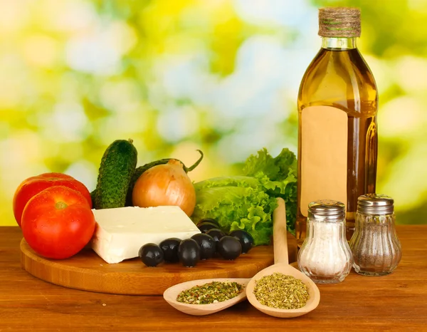 Ingredients for a Greek salad on green background close-up — Stock Photo, Image