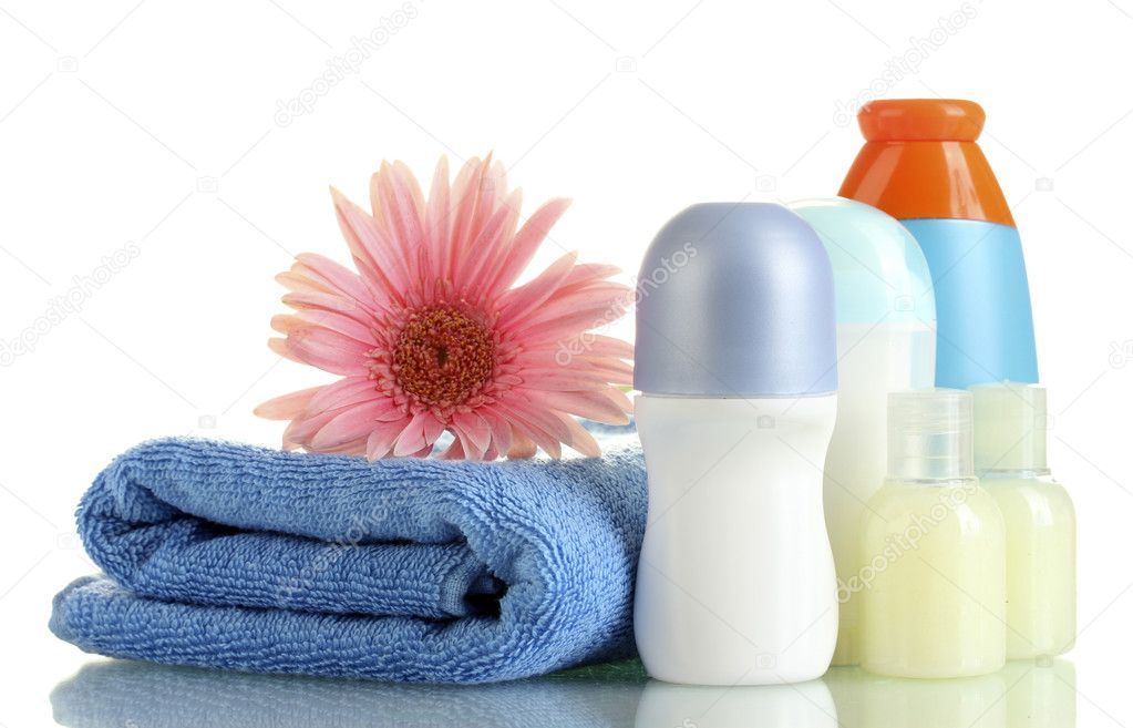 Cosmetics bottles with towel and flower isolated on white