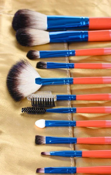 Set de pinceles de maquillaje en estuche de cuero dorado close up — Foto de Stock