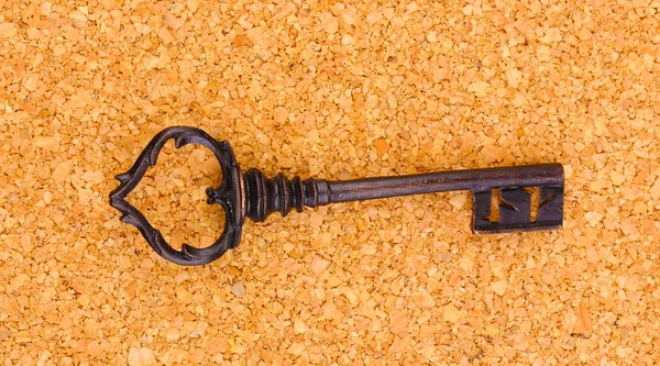 Античный ключ на пробковом фоне — стоковое фото