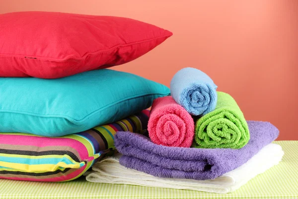Pillows and towels on red background — Stock Photo, Image