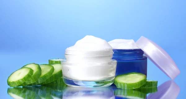 Cream and fresh sliced cucumber on blue background — Stock Photo, Image