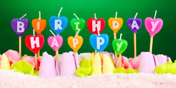 Verjaardagscake met kaarsen op groene achtergrond — Stockfoto
