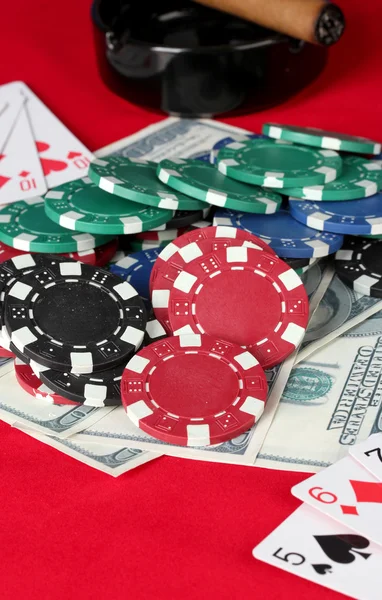 Tabulka červené pokerové hrací karty, poker žetony a dolary — Stock fotografie
