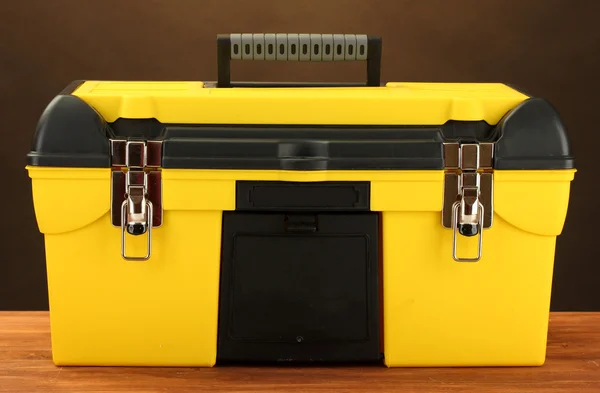 Caixa de ferramenta amarela no fundo marrom close-up — Fotografia de Stock