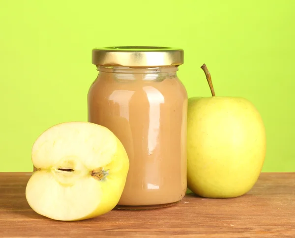 Burk med apple barnmat på träbord på färgstarka bakgrund närbild — Stockfoto