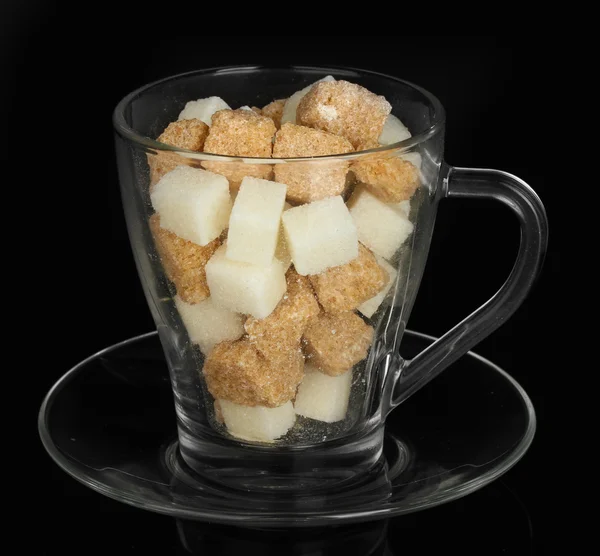 Bílý rafinovaný cukr a kusový hnědý třtinový cukr kostky ve sklenici izolované na černém — Stock fotografie