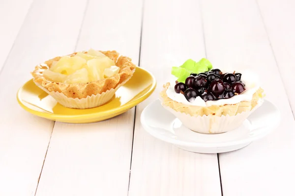 Сладкие пирожные с фруктами и ягодами на деревянном фоне — стоковое фото