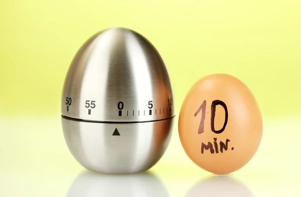 Χρονόμετρο αυγό και το αυγό στο πράσινο φόντο — Φωτογραφία Αρχείου
