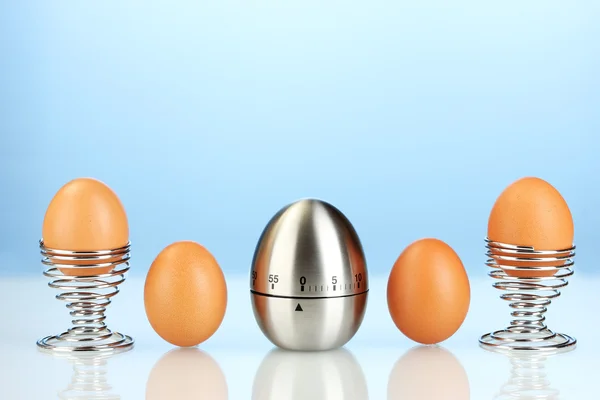 Egg 计时器和鸡蛋在蓝色背景 — 图库照片