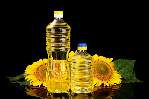 Sonnenblumenöl und Sonnenblume isoliert auf schwarz — Stockfoto