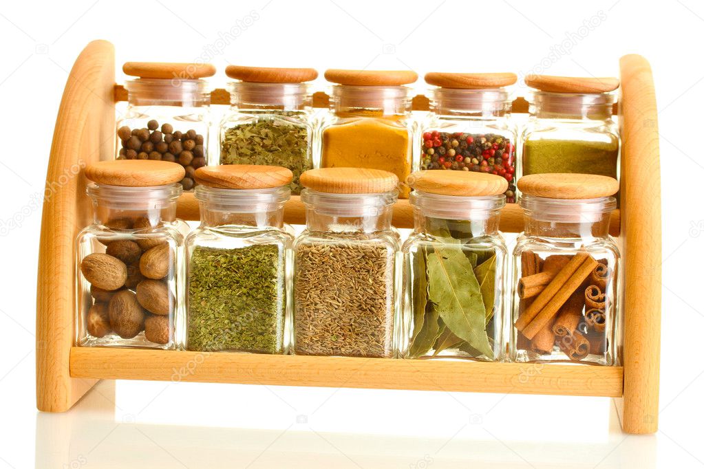 Powder spices in glass jars on wooden shelf isolated on white