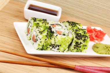 lezzetli rulo ile chopsticks açık renkli ahşap tablo üzerinde beyaz tabakta servis