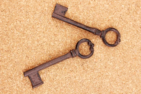 Два старинных ключа на пробковом фоне — стоковое фото
