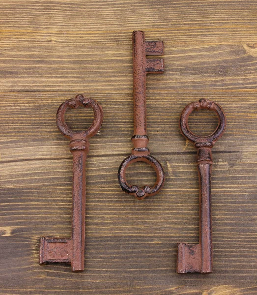 Ahşap zemin üzerinde üç antika anahtar — Stok fotoğraf