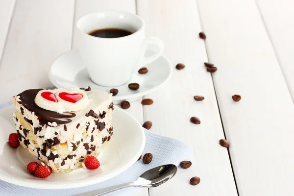 Bolo doce com chocolate na placa e xícara de café na mesa de madeira — Fotografia de Stock