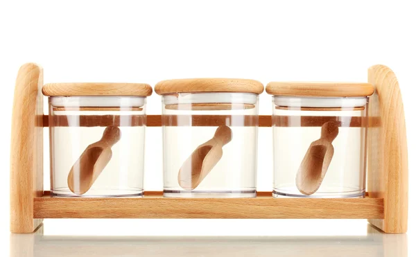 Lege glazen potten voor specerijen met lepels op houten plank geïsoleerd op wit — Stockfoto