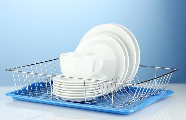 Clean dishes on stand on blue background — Stock Photo, Image