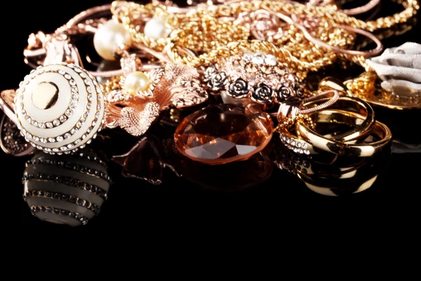 Various gold jewellery on black — Stock Photo, Image