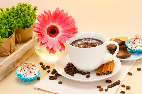 Чашка кофе и бобы гербера, коричные палочки на деревянном столе — стоковое фото