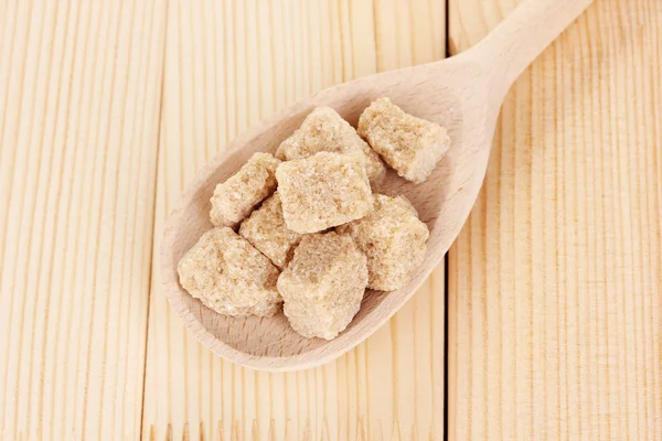Brauner Zucker in Löffel auf hölzernem Hintergrund — Stockfoto