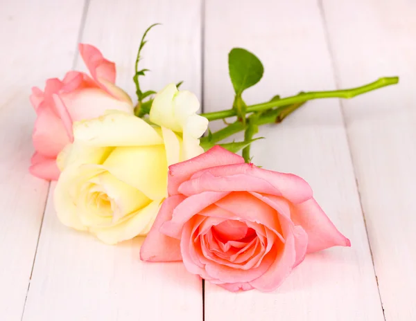 Три розы на деревянном фоне — стоковое фото