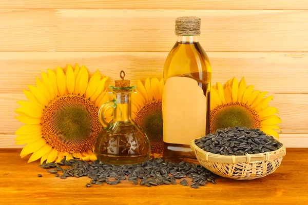 Olej słonecznikowy i słonecznik na tle drewna — Zdjęcie stockowe