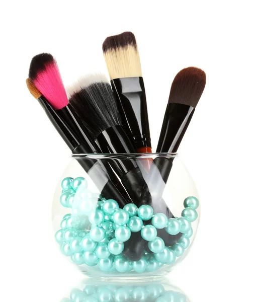 Cepillos de maquillaje en un tazón con collar de perlas aislado en blanco — Foto de Stock