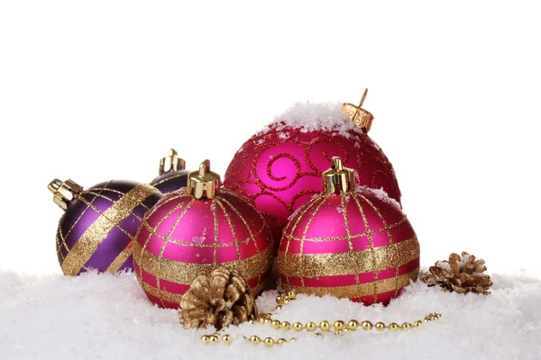 Güzel pembe Noel topları ve konileri üzerinde beyaz izole kar üzerinde — Stok fotoğraf