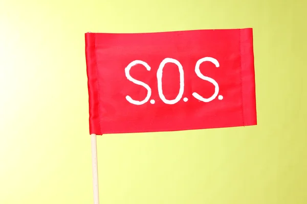 SOS signál na červenou látkou na zeleném pozadí — Stock fotografie