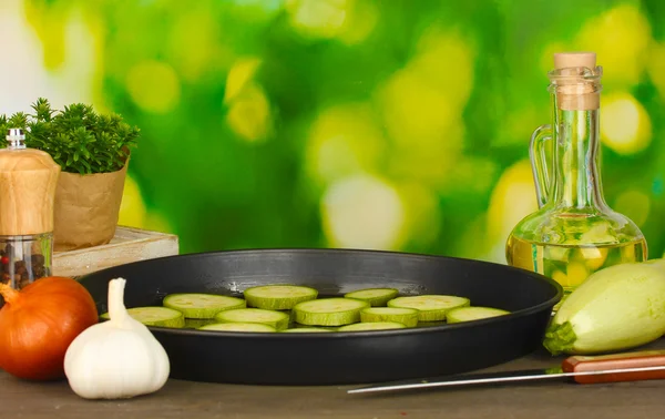 在木制桌子上的平底锅中切碎的南瓜，绿色背景特写 — 图库照片