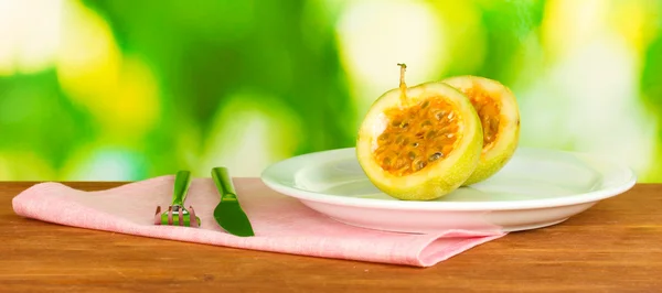 Green passion fruit in the plate on bright green background — Stock Photo, Image