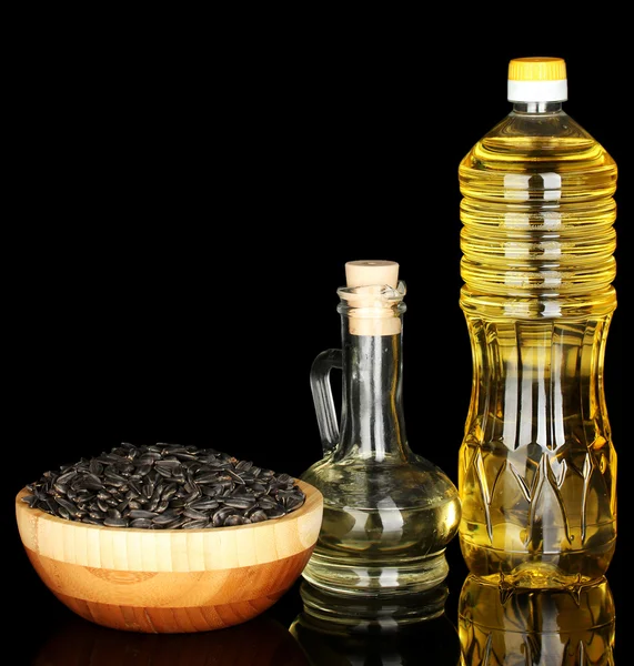 Olej słonecznikowy w butelkach na białym tle na czarnym tle — Zdjęcie stockowe