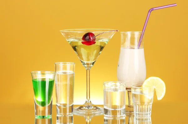 Une variété de boissons alcoolisées sur fond jaune — Photo
