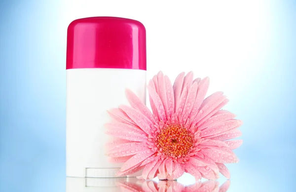 Deodorant with flower on blue background — Stock Photo, Image