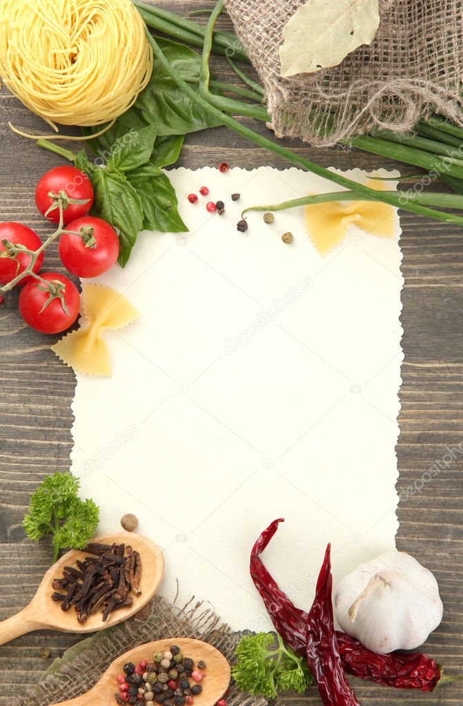 Paper for recipes vegetables, and spices on wooden table