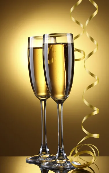 香槟和流光在黄色背景上的眼镜 — 图库照片