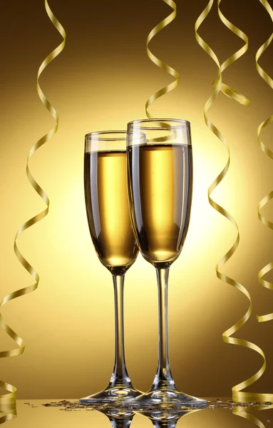 シャンパンと黄色の背景にストリーマーのメガネ — ストック写真